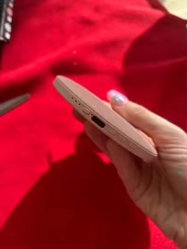Customer photo showing the slim edge and side controls of the pink pillow speaker
